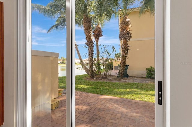 doorway featuring brick floor and a water view