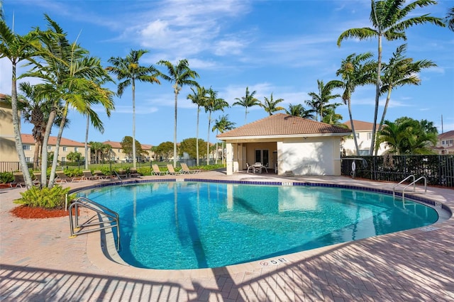 community pool with fence and a patio