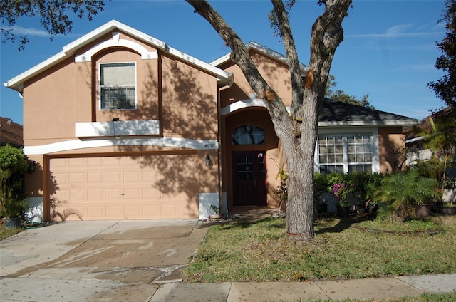 view of front of property featuring driveway, a front lawn, an attached garage, and stucco siding