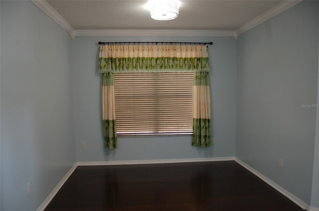 spare room with baseboards, ornamental molding, and wood finished floors