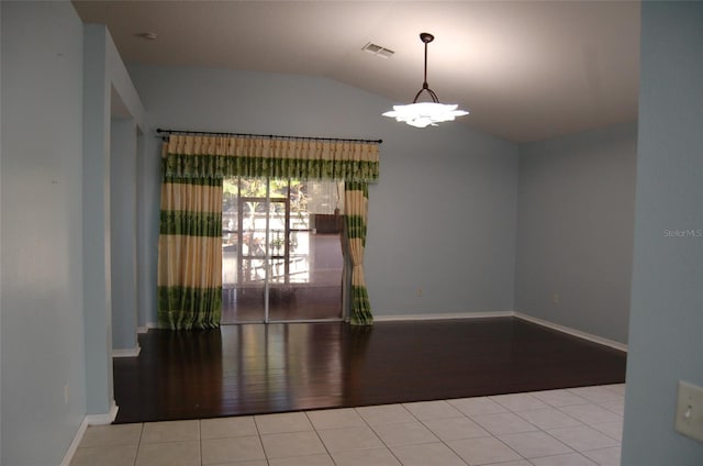 spare room featuring lofted ceiling, visible vents, an inviting chandelier, and tile patterned floors