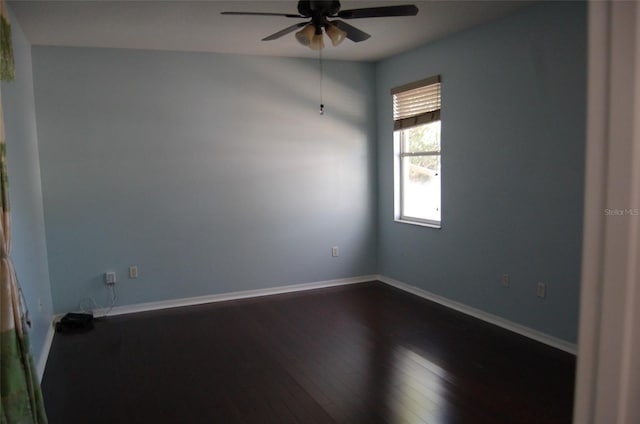 empty room with ceiling fan, dark wood-style flooring, and baseboards