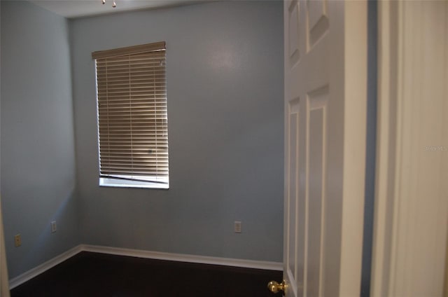 spare room with baseboards