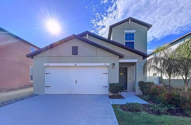 view of front of house with a garage, driveway, and stucco siding