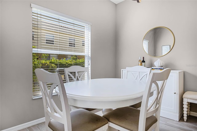 dining space featuring light wood-style flooring and baseboards