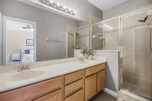 bathroom with a sink, a shower stall, and ensuite bathroom