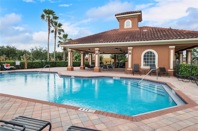 pool featuring a patio area, fence, and a ceiling fan