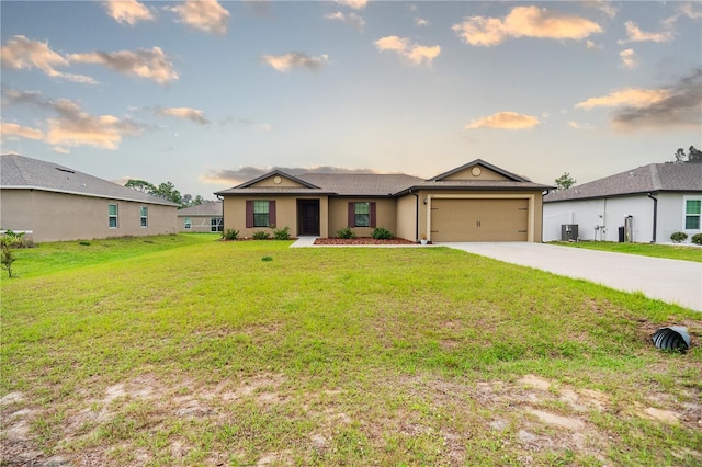 single story home featuring a garage, driveway, and a front lawn