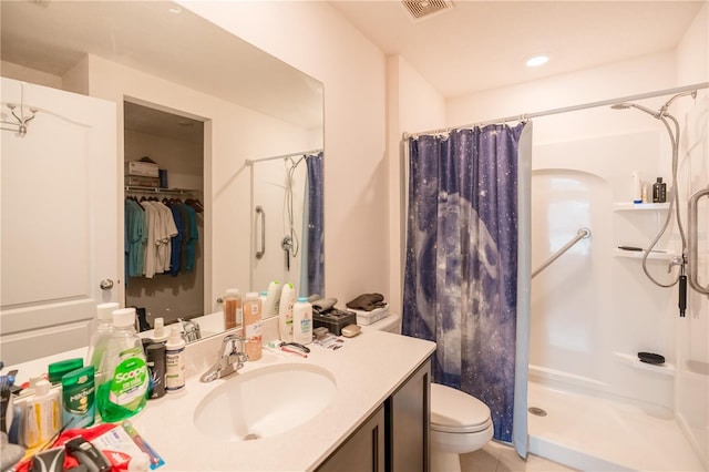 full bathroom with visible vents, vanity, a shower stall, and toilet