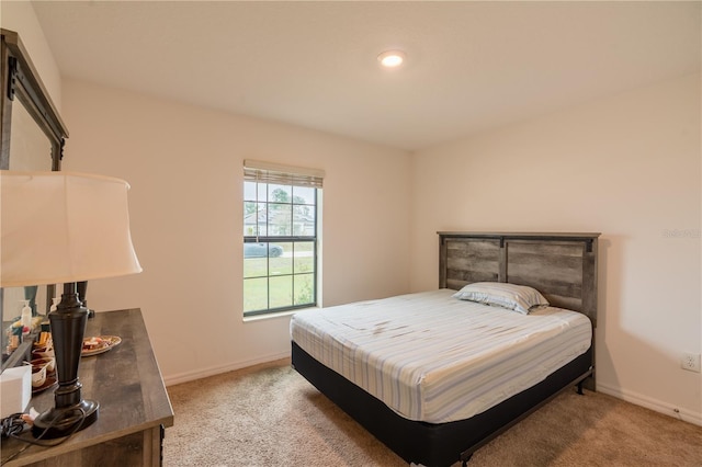 bedroom with light carpet and baseboards