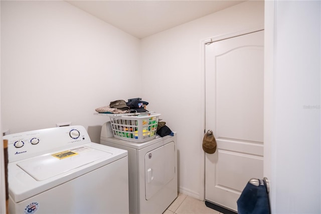 laundry room featuring light tile patterned floors, laundry area, and washer and clothes dryer