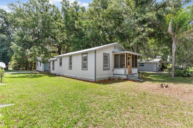 view of front facade with a front yard and a sunroom