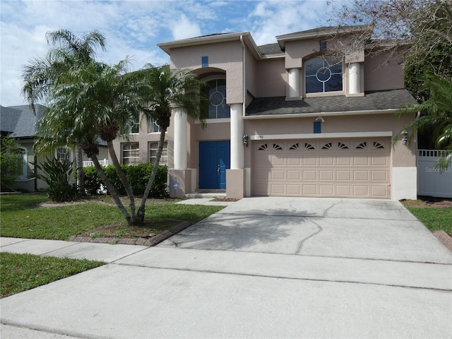 view of front facade with a garage, concrete driveway, and stucco siding