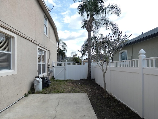 view of yard with a gate, a fenced backyard, and a patio