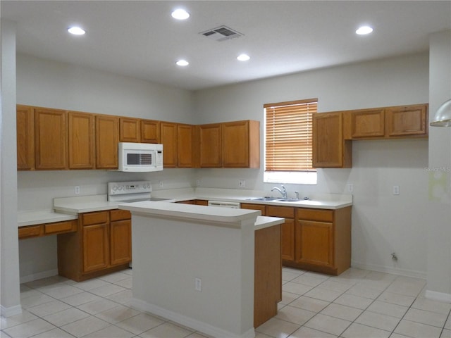 kitchen with brown cabinetry, visible vents, a sink, and white microwave