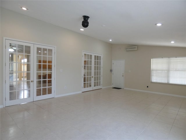 empty room with french doors, lofted ceiling, recessed lighting, a wall mounted air conditioner, and baseboards