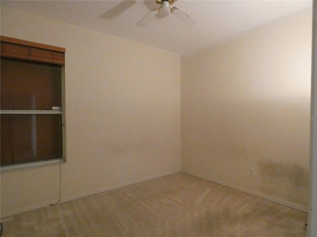 empty room with ceiling fan and baseboards