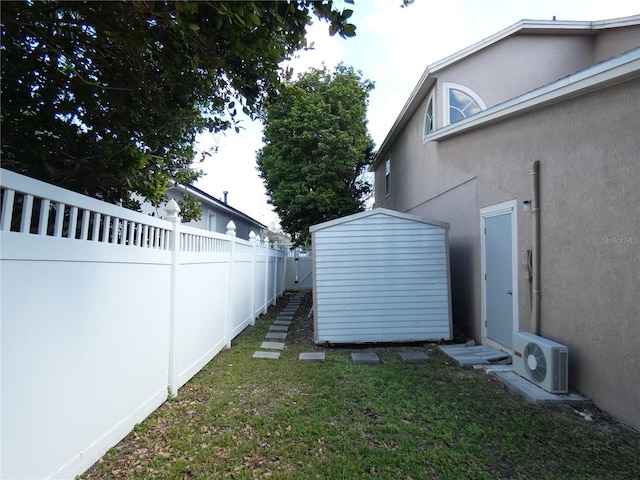 view of yard featuring ac unit, fence private yard, an outdoor structure, and a shed