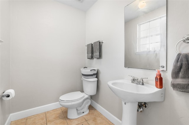 bathroom with toilet, tile patterned flooring, and baseboards