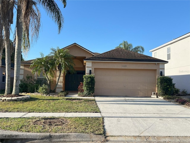 view of front of home featuring stucco siding, a garage, and driveway