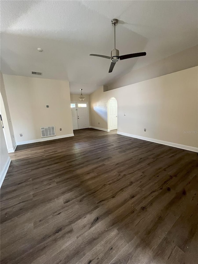 unfurnished living room featuring lofted ceiling, dark wood-style floors, a ceiling fan, and visible vents