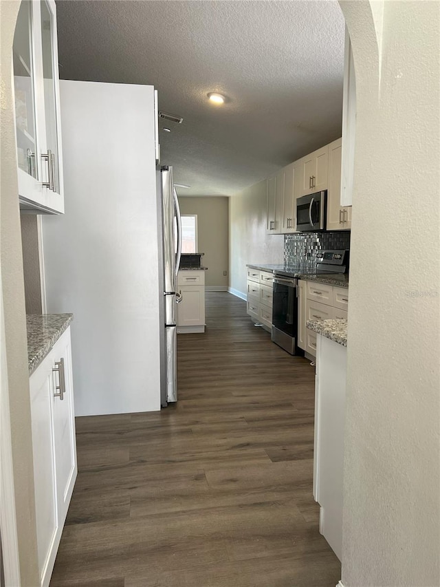 kitchen featuring appliances with stainless steel finishes, white cabinets, and dark wood-style flooring