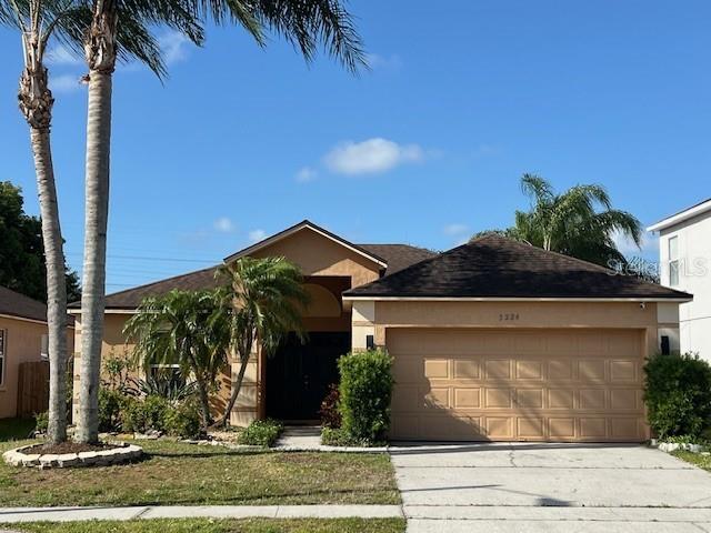 single story home featuring stucco siding, concrete driveway, and an attached garage