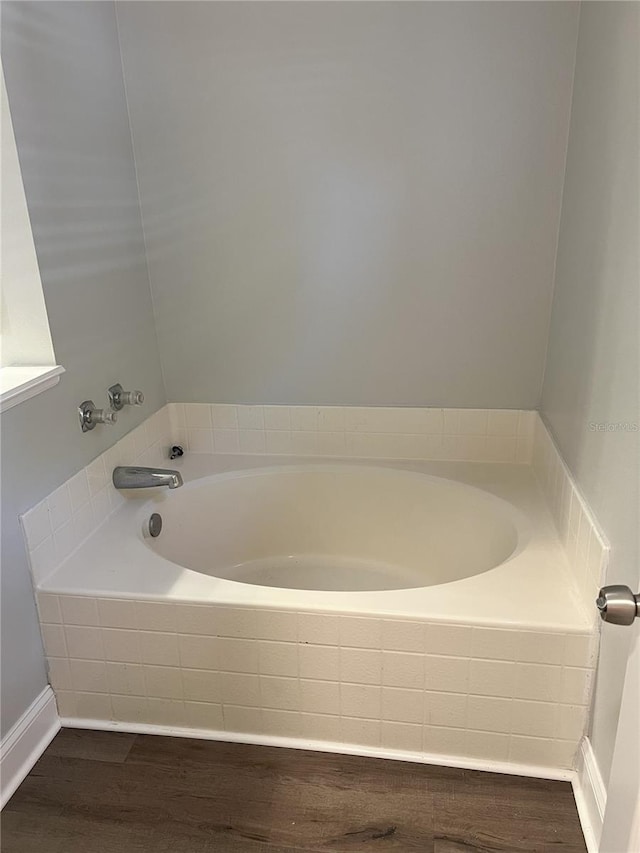 bathroom featuring wood finished floors and a garden tub