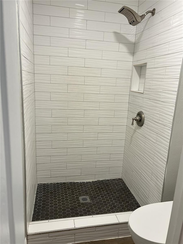 bathroom featuring toilet and a stall shower