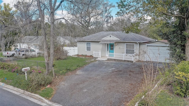 view of front of property featuring an attached garage, driveway, fence, and a front yard