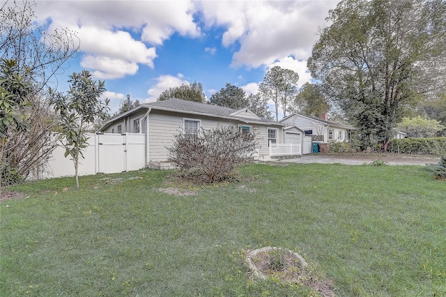 view of front of home featuring a gate, fence, a garage, driveway, and a front lawn