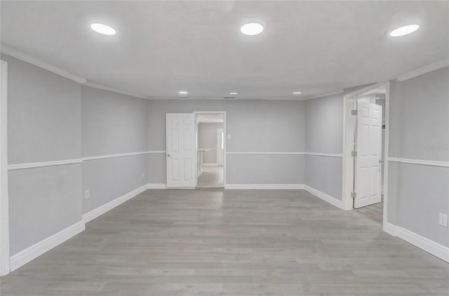 empty room featuring crown molding, recessed lighting, wood finished floors, and baseboards