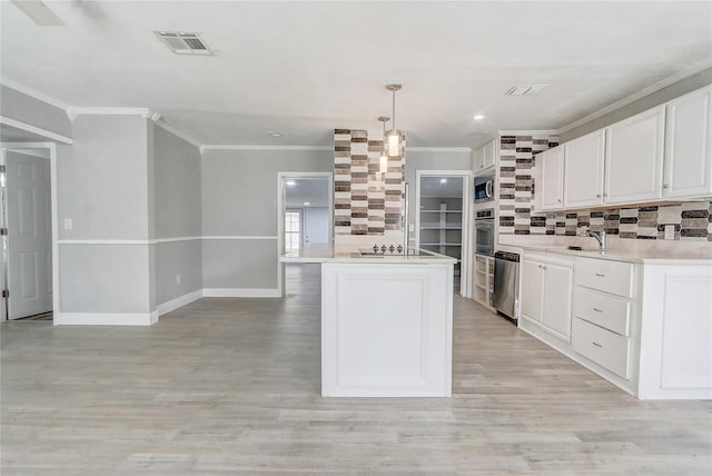 kitchen with tasteful backsplash, visible vents, appliances with stainless steel finishes, light countertops, and light wood-style floors