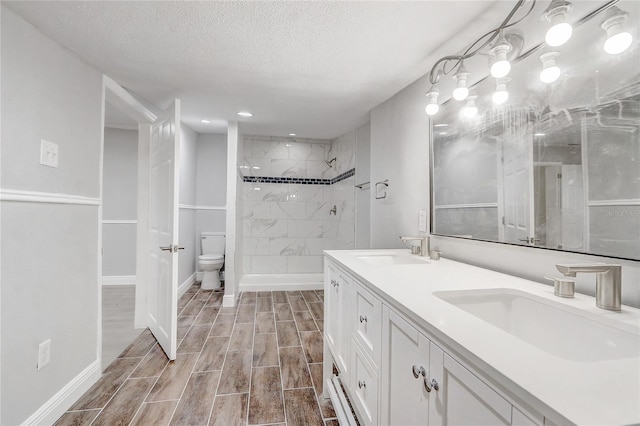 full bath featuring wood finish floors, a sink, a shower stall, and baseboards