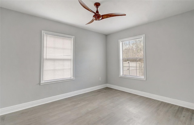 empty room featuring ceiling fan, wood finished floors, and baseboards