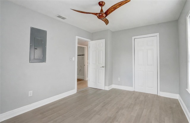 unfurnished bedroom featuring visible vents, wood finished floors, electric panel, and baseboards