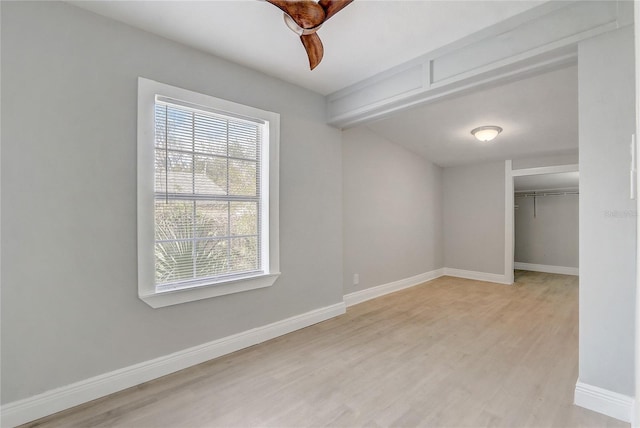 unfurnished bedroom featuring a closet, light wood-type flooring, and baseboards