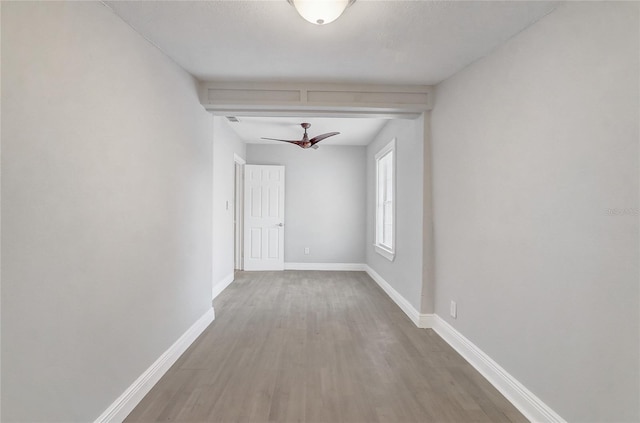 hallway with baseboards and wood finished floors