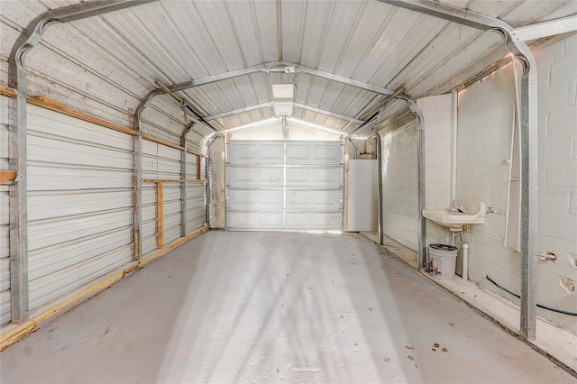 garage with metal wall, concrete block wall, and a garage door opener