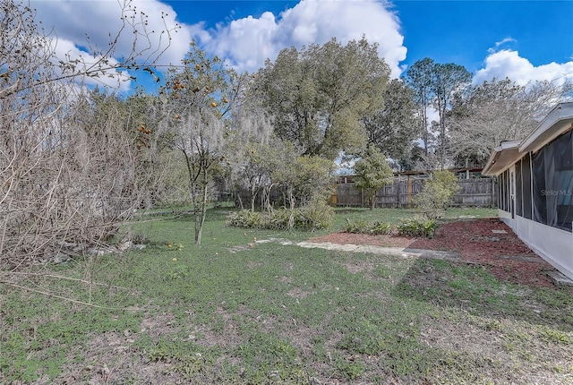 view of yard with a sunroom and fence