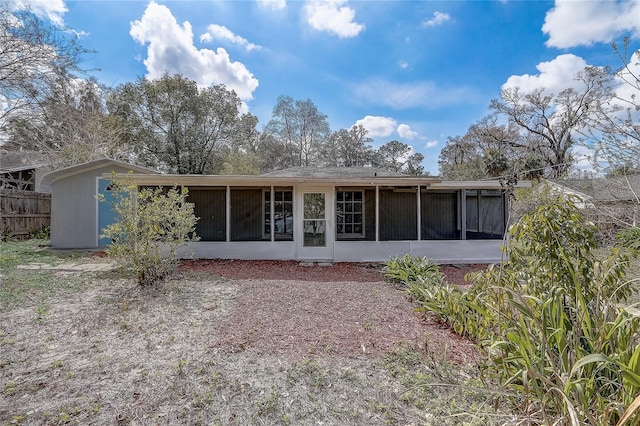 back of house featuring a sunroom and fence