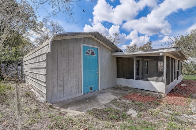 view of outbuilding featuring an outbuilding and a sunroom