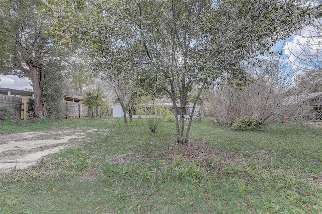 view of yard featuring fence and an outbuilding