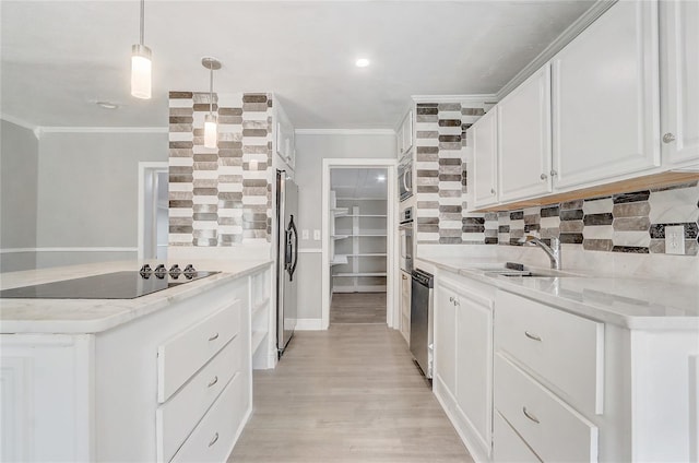 kitchen with tasteful backsplash, ornamental molding, white cabinets, a sink, and stainless steel appliances