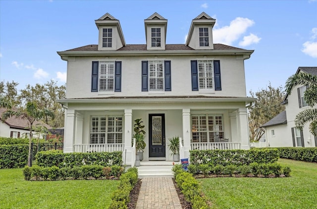 view of front of property featuring a porch, a front lawn, and stucco siding