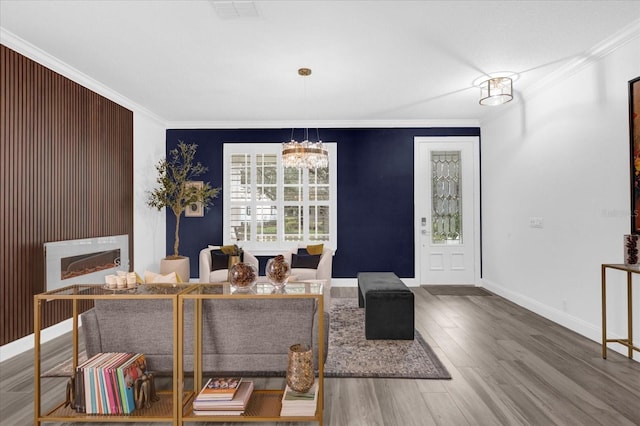 foyer entrance featuring baseboards, a notable chandelier, ornamental molding, and wood finished floors