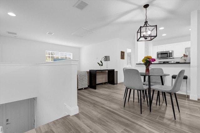 dining room featuring light wood finished floors, visible vents, and recessed lighting