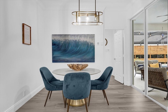 dining space with baseboards, wood finished floors, and crown molding