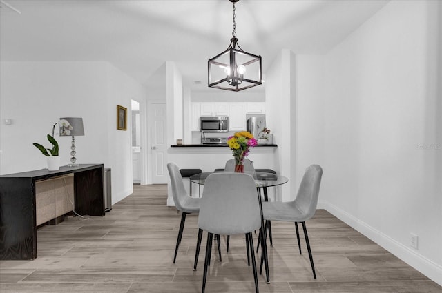 dining room featuring light wood-style flooring and baseboards