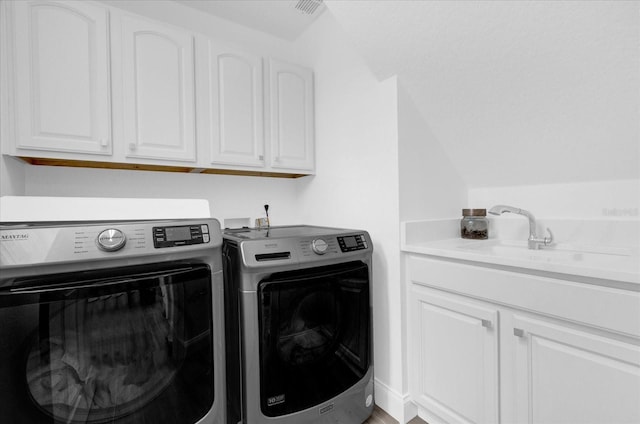 laundry room with a sink, visible vents, washing machine and dryer, and cabinet space